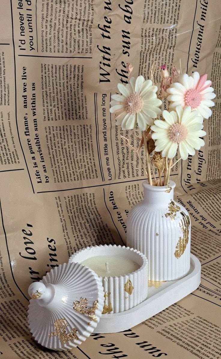 Ivory fluted candle and vase with gold leaf detail on an oval tray