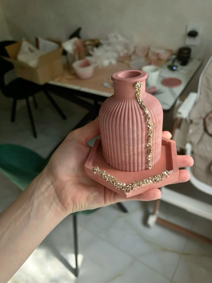 Rose pink ribbed bud vase with gold detail on a matching tray