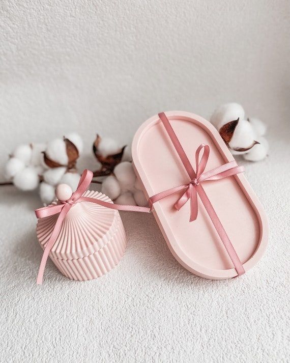 Pink oval tray and ribbed lidded jar tied with satin ribbon