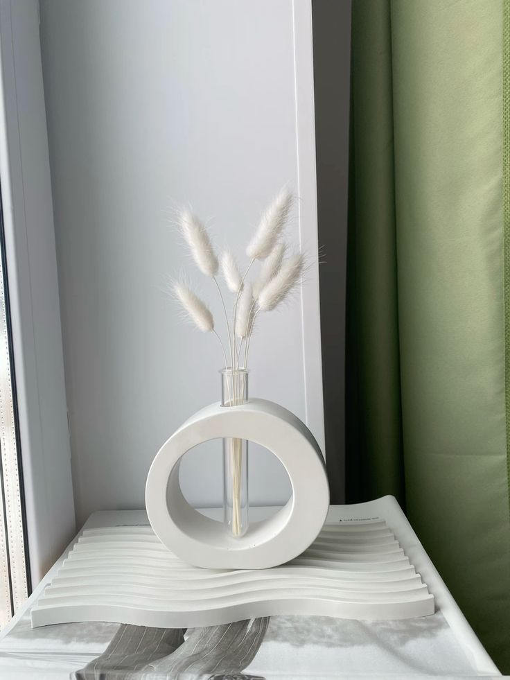 White sculptural vase with dried flowers